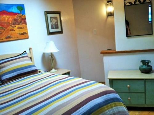 een slaapkamer met een bed, een dressoir en een spiegel bij Casas de Guadalupe - Sante Fe Vacation Rentals in Santa Fe