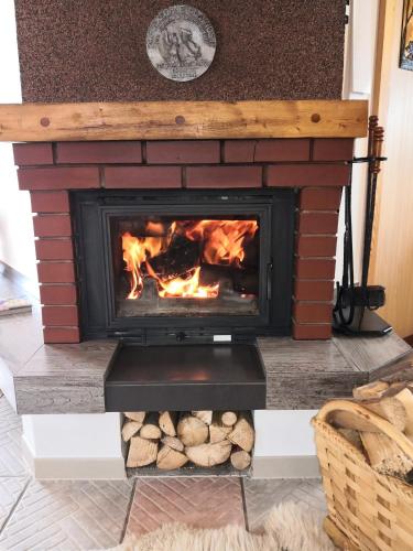 a brick fireplace with a fire in it at Chata pod pilskom in Sihelné