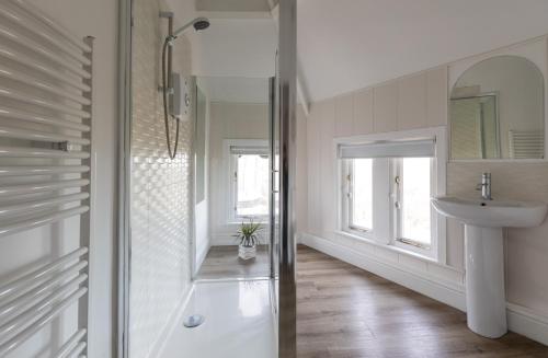 La salle de bains est pourvue d'une douche en verre et d'un lavabo. dans l'établissement Beach View Apartment, à Saltburn-by-the-Sea