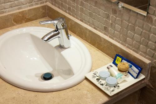 a bathroom sink with aaucet and toothbrushes andsein at Swiss Royal DAHAB in Dahab