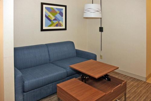 a living room with a blue couch and a table at Holiday Inn Express Branford-New Haven by IHG in Branford