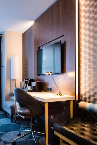 a hotel room with a desk and a tv on a wall at Crowne Plaza HY36 Midtown Manhattan by IHG in New York