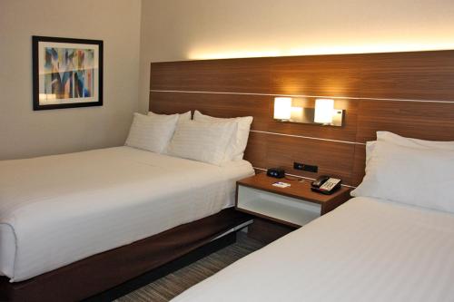 a hotel room with two beds and a night stand at Holiday Inn Express Branford-New Haven by IHG in Branford