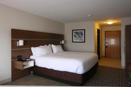 a hotel room with a large bed and a door at Holiday Inn Express Branford-New Haven by IHG in Branford