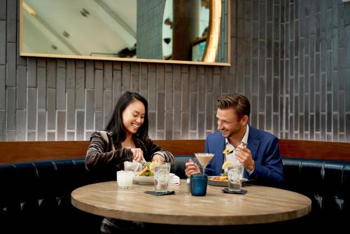 a man and woman sitting at a table eating food at Crowne Plaza HY36 Midtown Manhattan by IHG in New York