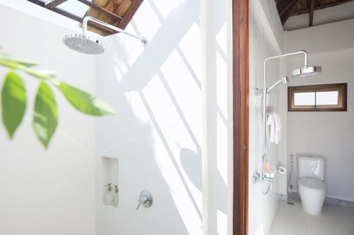 a bathroom with a shower and a toilet at Mira Montra Resort Koh Mak in Ko Mak