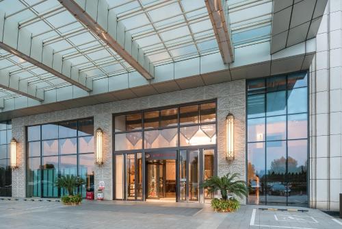 a rendering of a building with large glass windows at Crowne Plaza Yichang by IHG in Yichang