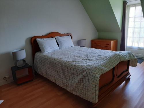 a bedroom with a large bed with a wooden floor at Gîte de la Fouquetière in Pontorson