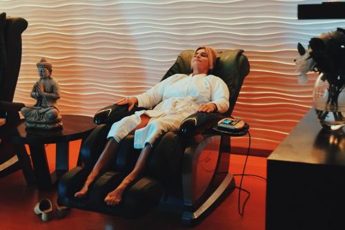 a woman sitting in a chair in a room at Howard Johnson Resort & Convention Center Ezeiza in Ezeiza