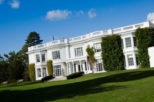 a large white house on a lush green field at Greenlands Hotel in Henley on Thames