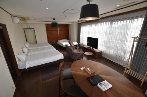 a room with a bed and a desk and a table at Randor Residence Tokyo Grand in Tokyo