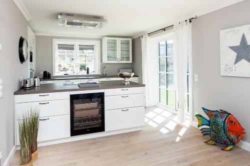 a kitchen with white cabinets and a stove at Beachalm in List