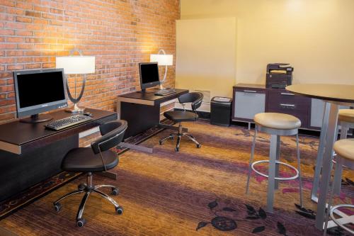 an office with desks and chairs and a brick wall at Crowne Plaza Minneapolis West by IHG in Plymouth