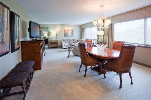 a living room with a wooden table and a dining room at Crowne Plaza Minneapolis West by IHG in Plymouth