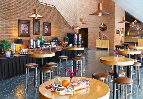 a restaurant with wooden tables and stools in a room at Crowne Plaza Minneapolis West by IHG in Plymouth