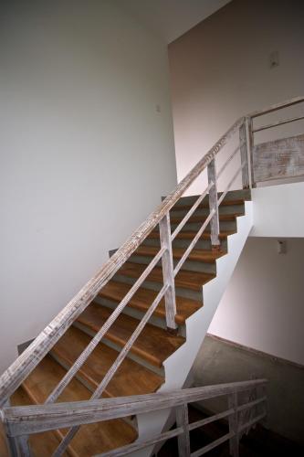 a staircase in a white room with wooden floors at Roman Beach Hotel in Hikkaduwa