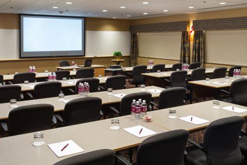 a conference room with tables and chairs and a screen at Crowne Plaza Minneapolis West by IHG in Plymouth