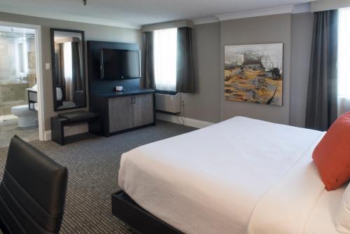 a hotel room with a bed and a flat screen tv at Crowne Plaza Fredericton Lord Beaverbrook by IHG in Fredericton