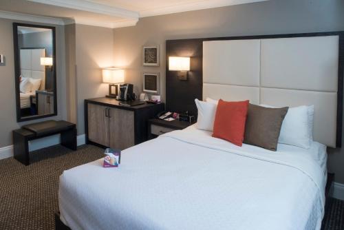 a hotel room with a large white bed with red pillows at Crowne Plaza Fredericton Lord Beaverbrook by IHG in Fredericton