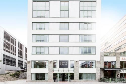 a white building with a sign on it at Biz Apartment Hammarby Sjöstad in Stockholm