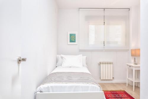 ein weißes Schlafzimmer mit einem Bett und einem Fenster in der Unterkunft iloftmalaga Reding in Málaga