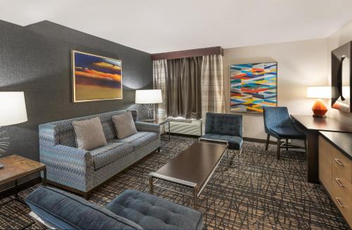 a living room with a couch and chairs in a hotel room at Crowne Plaza Annapolis by IHG in Annapolis