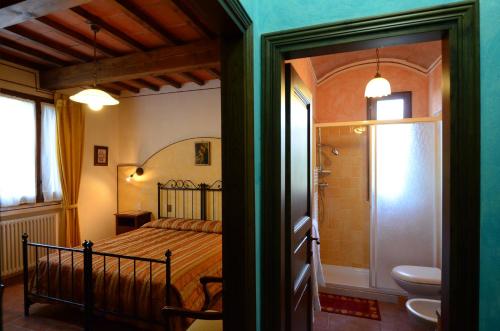 a bedroom with a bed and a bathroom with a toilet at Agriturismo La Casella in Castelfranco di Sopra