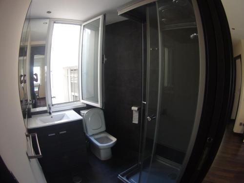 y baño con aseo, lavabo y ducha. en Coqueto apartamento de 2 habitaciones en zona estación tren en A Coruña