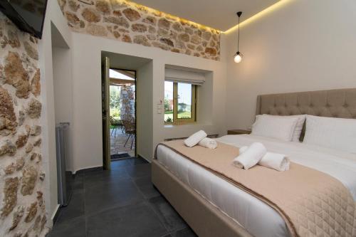 a bedroom with a bed with white pillows on it at Acrothea Perdika in Perdika