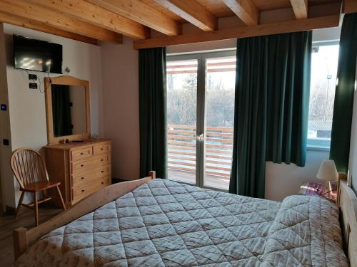 1 dormitorio con 1 cama, TV y ventana en Az. Agr. Sponga Giancarlo, en Lèvego