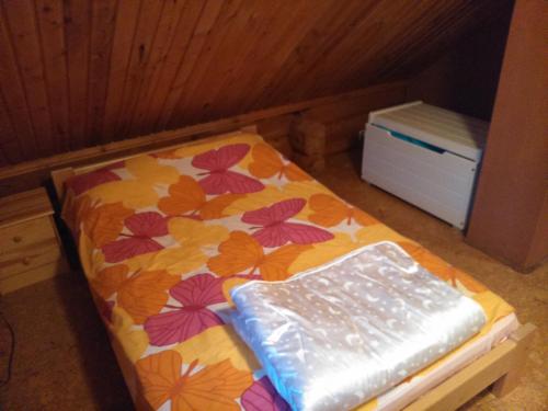 a small bed in a room with a flower pattern at Vana-Laane Puhkemaja in Otepää