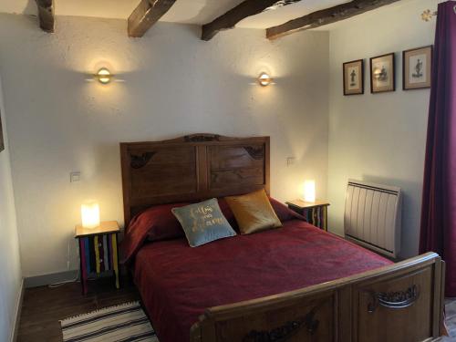 1 dormitorio con 1 cama con sábanas rojas y 2 lámparas en Gîte des 2 frères, en Saint-Pierre-de-Maillé