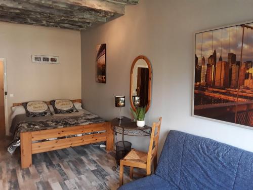 a bedroom with a bed and a couch and a mirror at ancienne maison des templiers in Gouillons