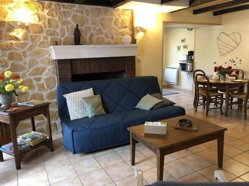- un salon avec un canapé bleu et une cheminée dans l'établissement Gîte des 2 frères, à Saint-Pierre-de-Maillé