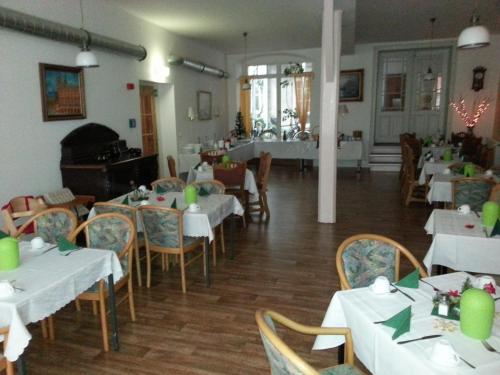 a dining room with white tables and chairs and a room with tables and chairsktop at Altstadt Pension Hafenblick in Stralsund
