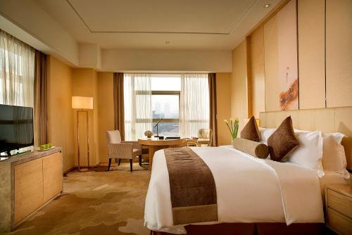 a hotel room with a bed and a television at Expo Center Hotel - Free Shuttle Bus & Late Check-out in Yiwu