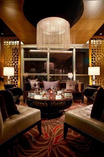 a living room with a chandelier and a table and chairs at Expo Center Hotel - Free Shuttle Bus & Late Check-out in Yiwu