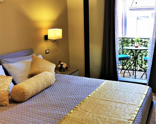 a bedroom with a bed and a balcony with a table at Casa Le Maioliche in Giardini Naxos