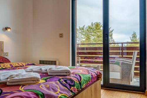 Un dormitorio con una cama y un balcón. en Apartment Victory in Vila Pekovic, en Zlatibor