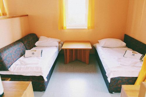 a small room with two beds and a table at Terme Olimia - Apartment Village Lipa in Podčetrtek