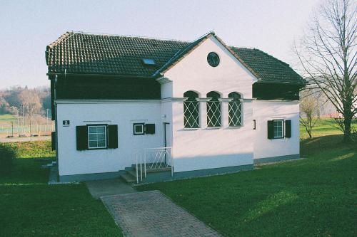 a small white house with a green roof at Terme Olimia - Apartment Village Lipa in Podčetrtek