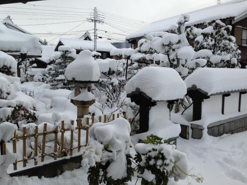 a fence covered in snow in a garden at 快適なアメリカ製トレーラーハウスで非日常グランピング in Maibara