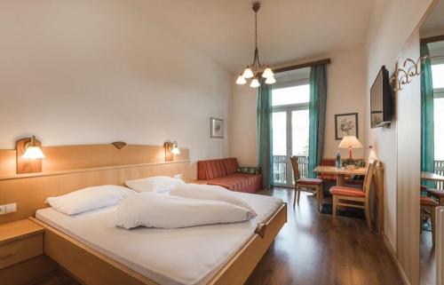 1 dormitorio con 1 cama grande y sala de estar en Hotel Angelica, en Merano