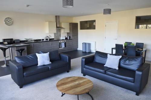 uma sala de estar com dois sofás e uma mesa em Toothbrush Apartments - Ipswich Central East em Ipswich