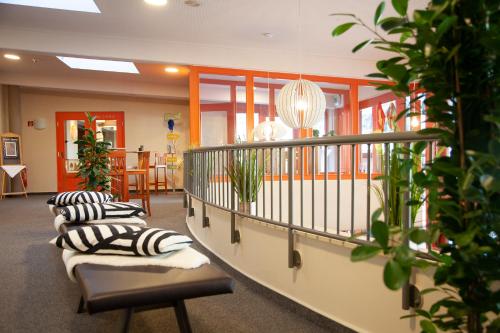 a waiting room with couches and plants at JUFA Hotel Mariazell in Mariazell