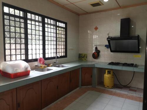 a kitchen with two sinks and a flat screen tv at Shangrila House @ 香格里拉民宿 in Tawau