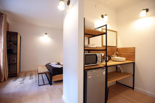 a small room with a kitchen and a room with a microwave at Neue Gasse Lviv apartments in Lviv