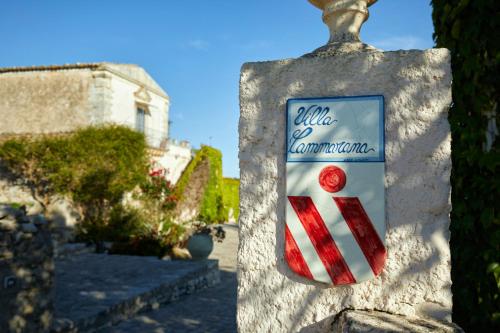 a sign for a restaurant on a stone wall at Villa Cammarana in Ragusa