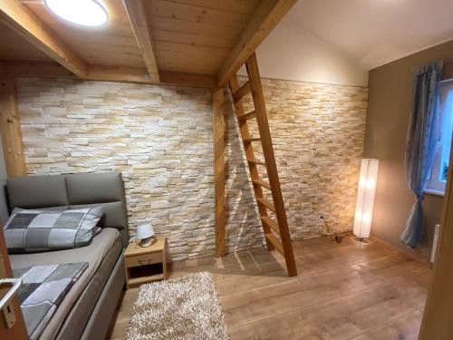 a room with a couch and a brick wall at Reiger Ferienwohnungen in Wackersdorf
