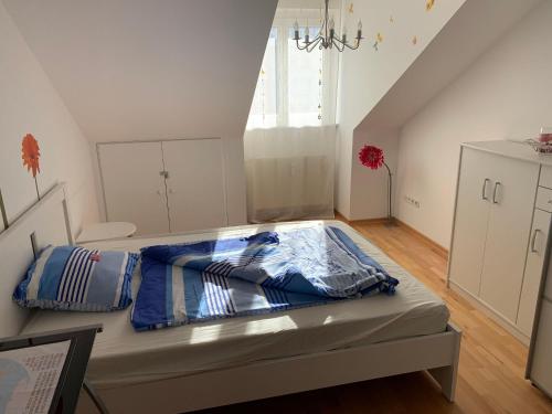 ein Schlafzimmer mit einem Bett mit einer blauen Decke darauf in der Unterkunft Ferienwohnung Elena in Oberstaufen